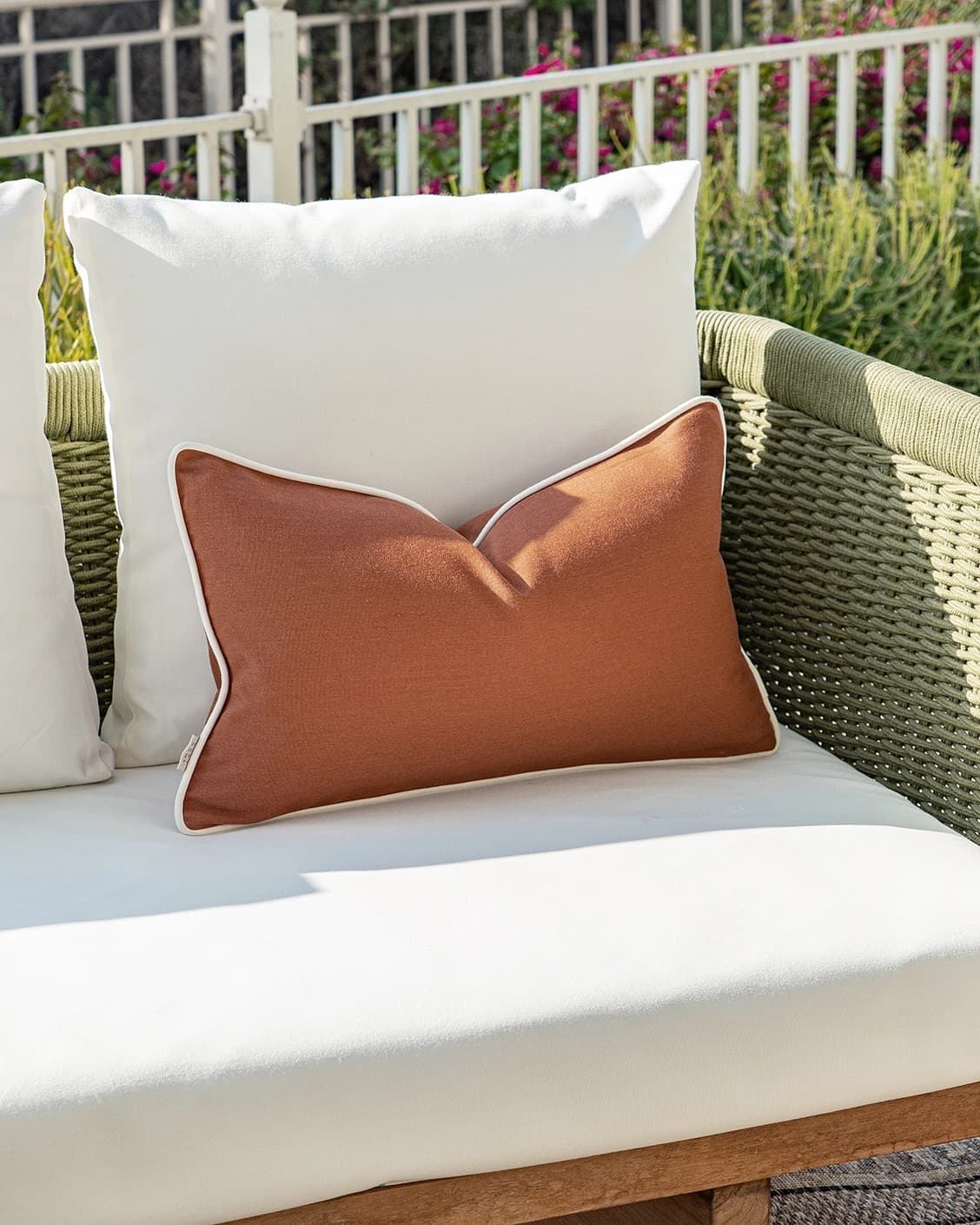 Aelia Clay II cushion in rust, shown in a lifestyle left view as image 2