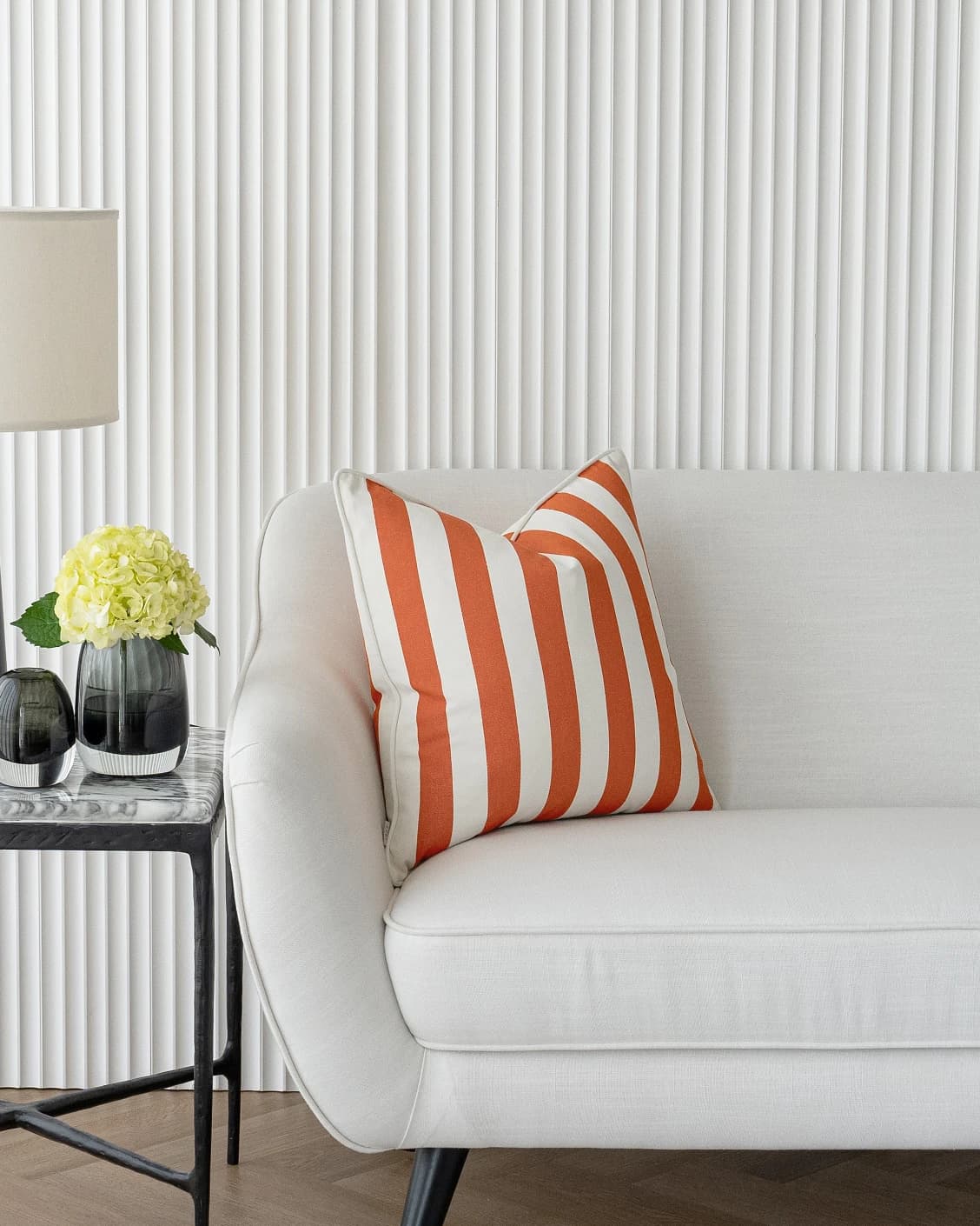 Aelia Coral cushions in coral and orange, shown in a lifestyle left view as video image