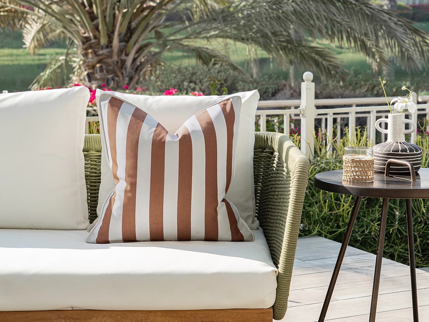 Aelia Rust single cushions in rust and ivory, shown in a lifestyle front view