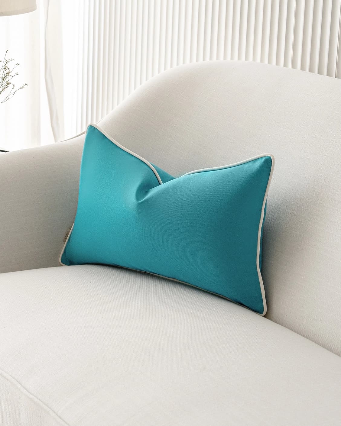 Aelia Sky II cushion in coral and blue, shown in a lifestyle right view as image 2