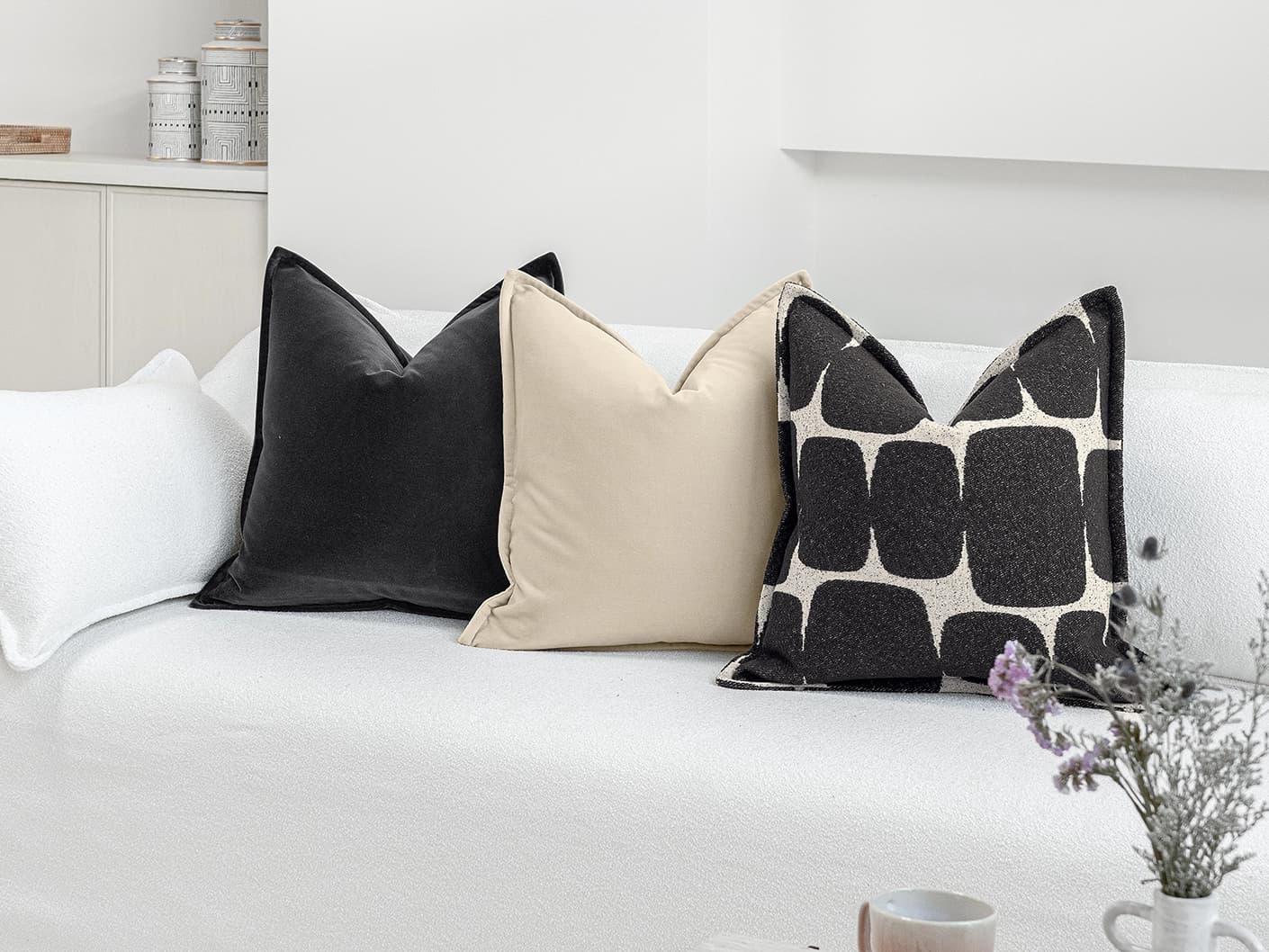 Aijan Bundle bundle cushions in beige, grey and charcoal, shown in a lifestyle front view