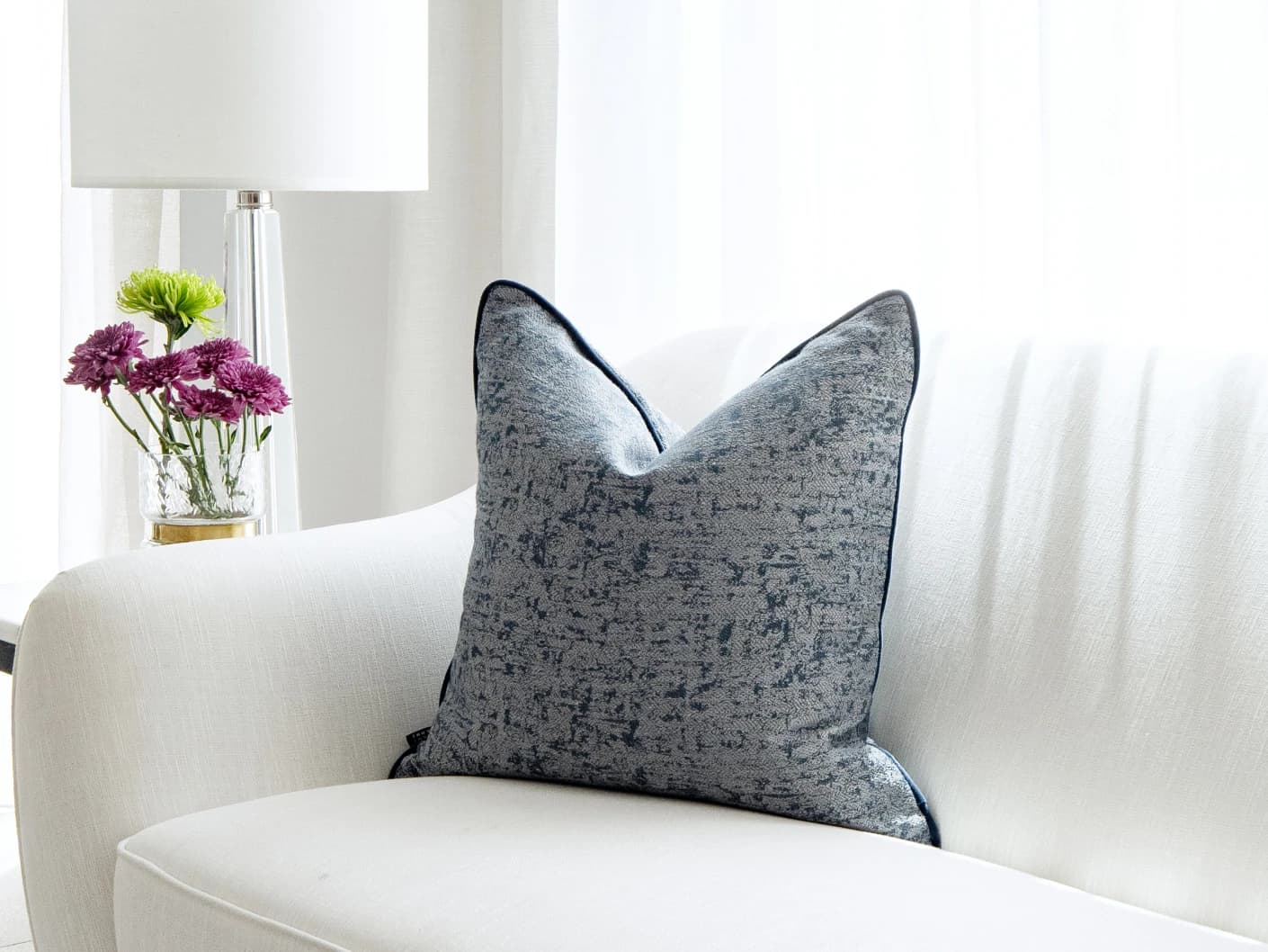 Alba Canova single cushions in navy, grey and blue, shown in a lifestyle left view