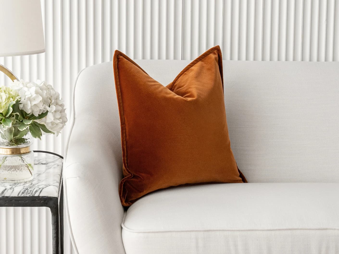 Alessandra Rust single cushions in rust and orange, shown in a lifestyle front view
