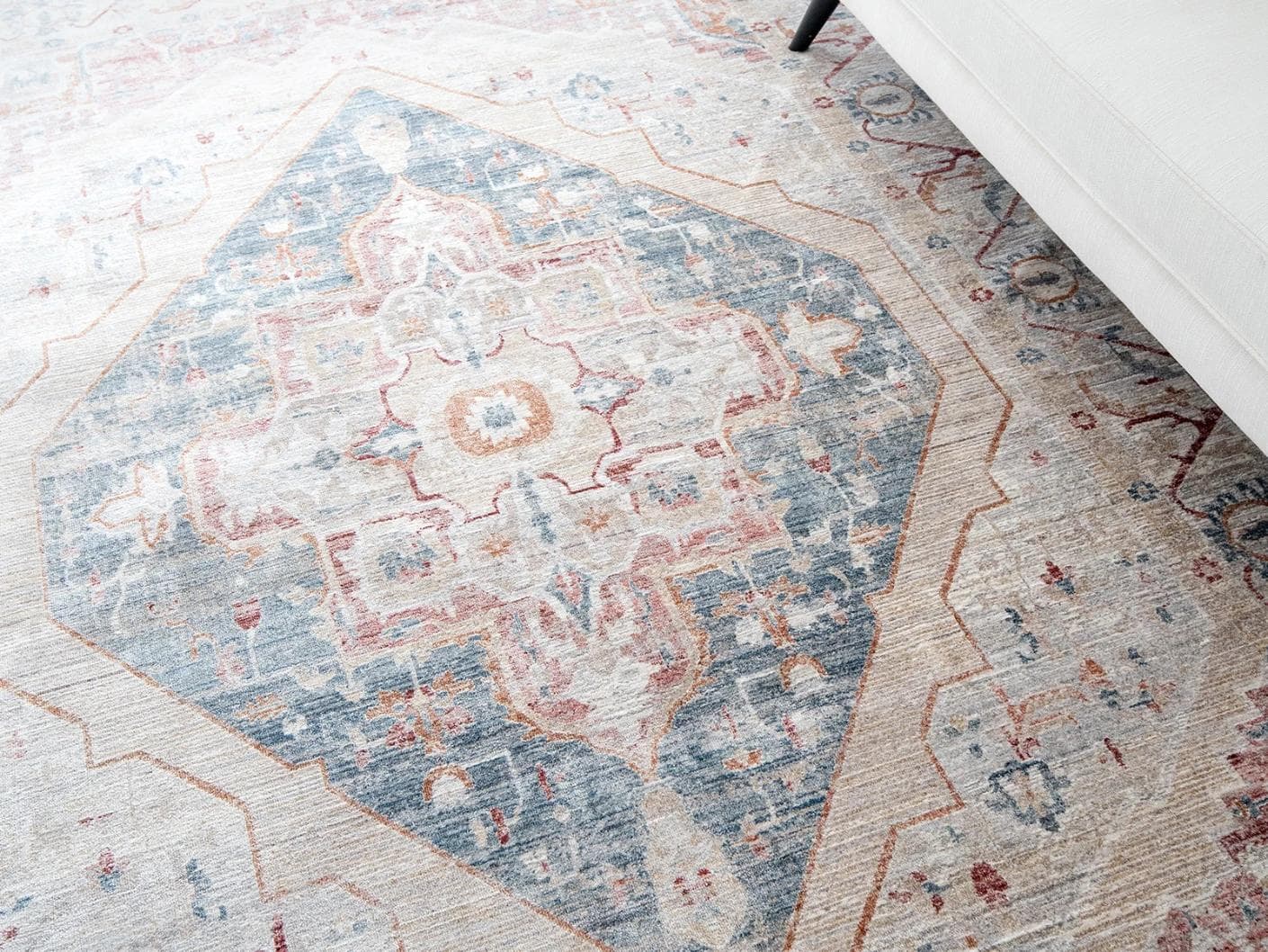 Alexander Rouge carpets in beige, blue and red, shown in a lifestyle close-up as image 2