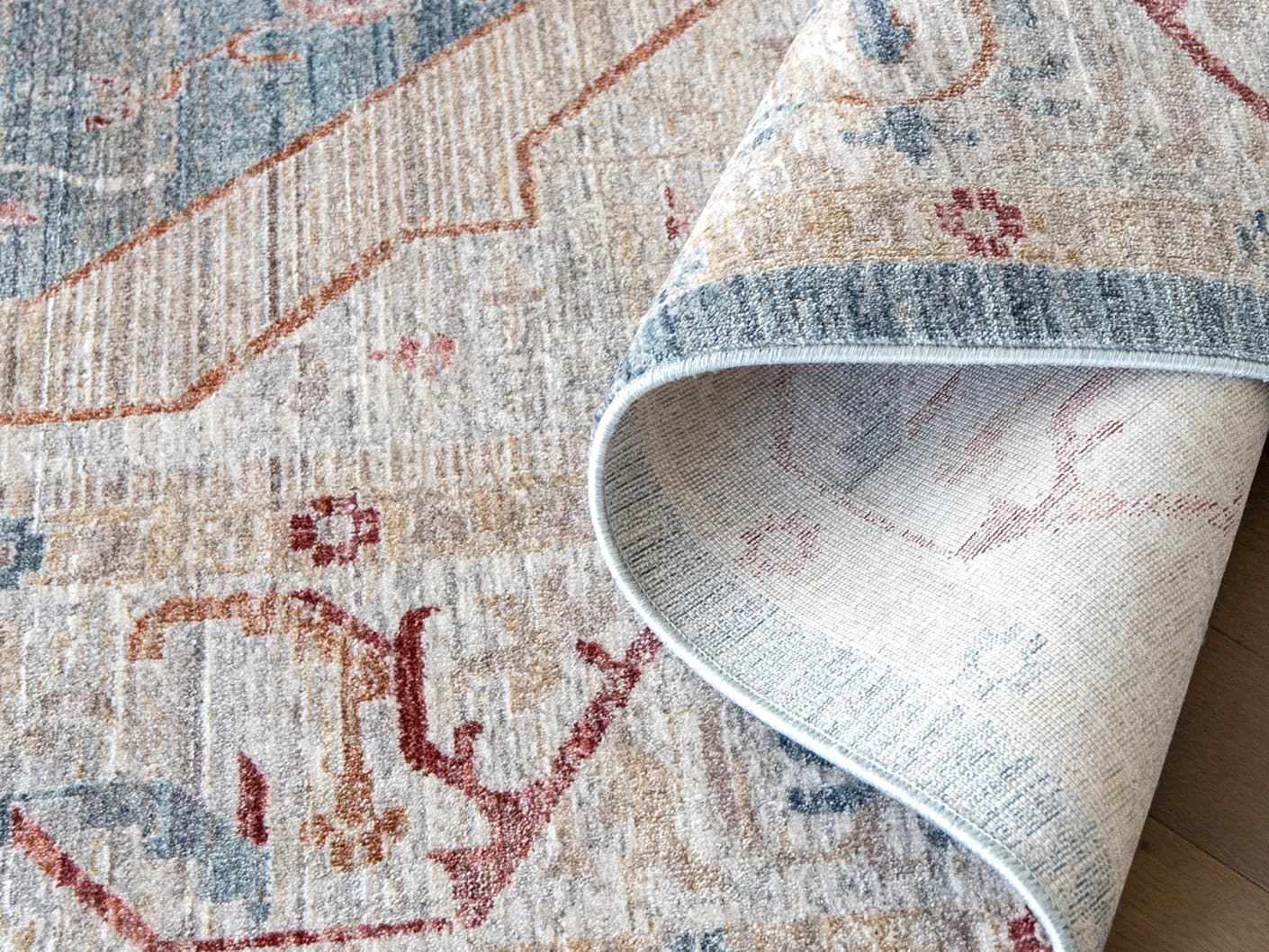 Alexander Rouge carpets in beige, blue and red, shown in a product close-up view