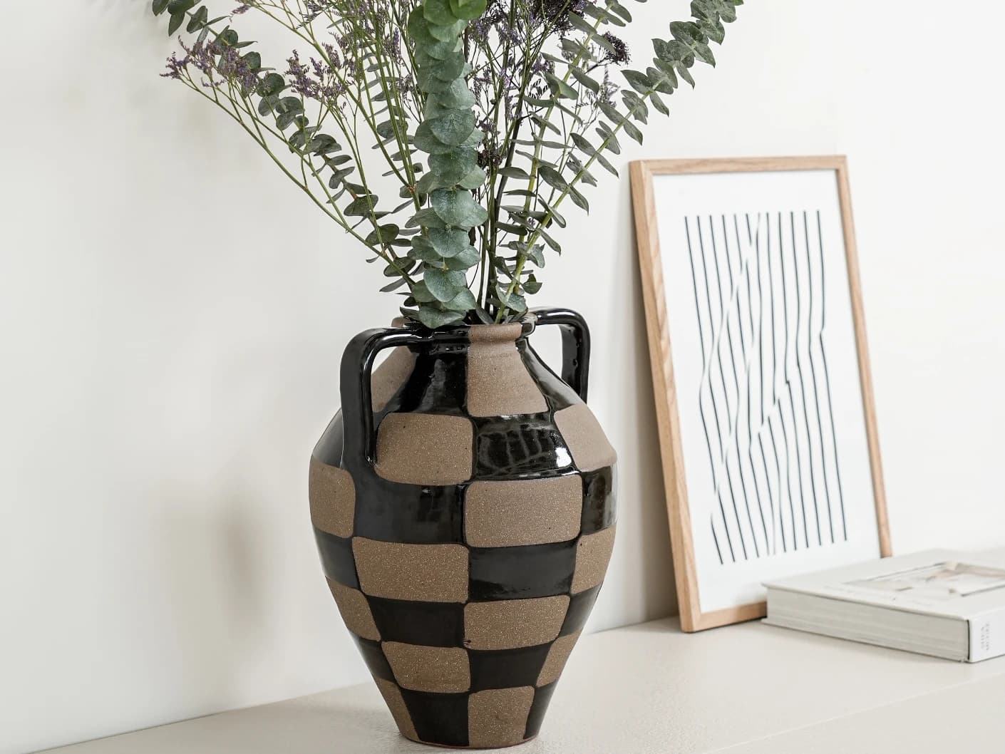 Alisca Terra vases in charcoal black, warm clay, brown and black, shown in a lifestyle left view