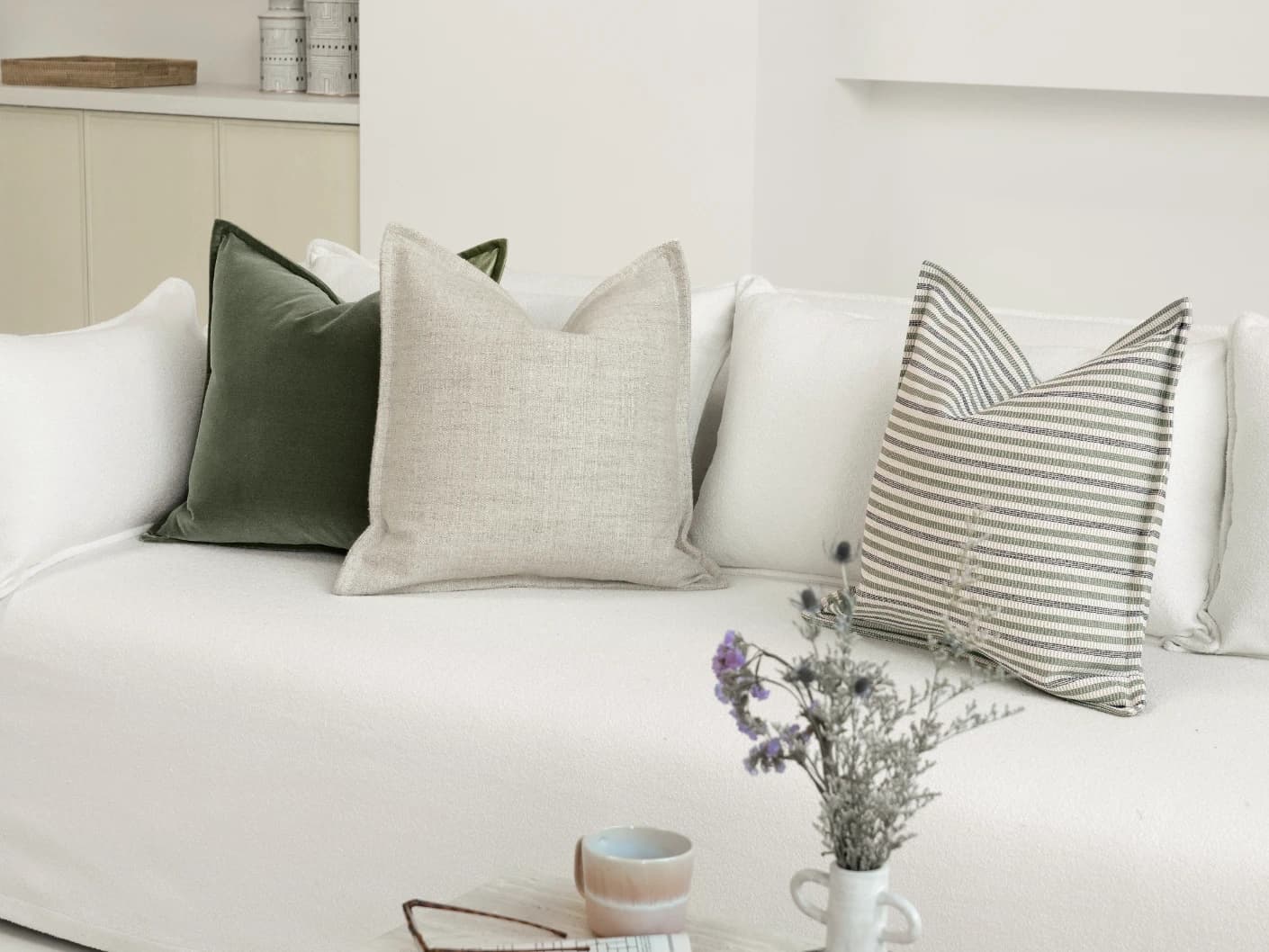 Aliva Bundle bundle cushions in ivory, green and off white, shown in a lifestyle front view