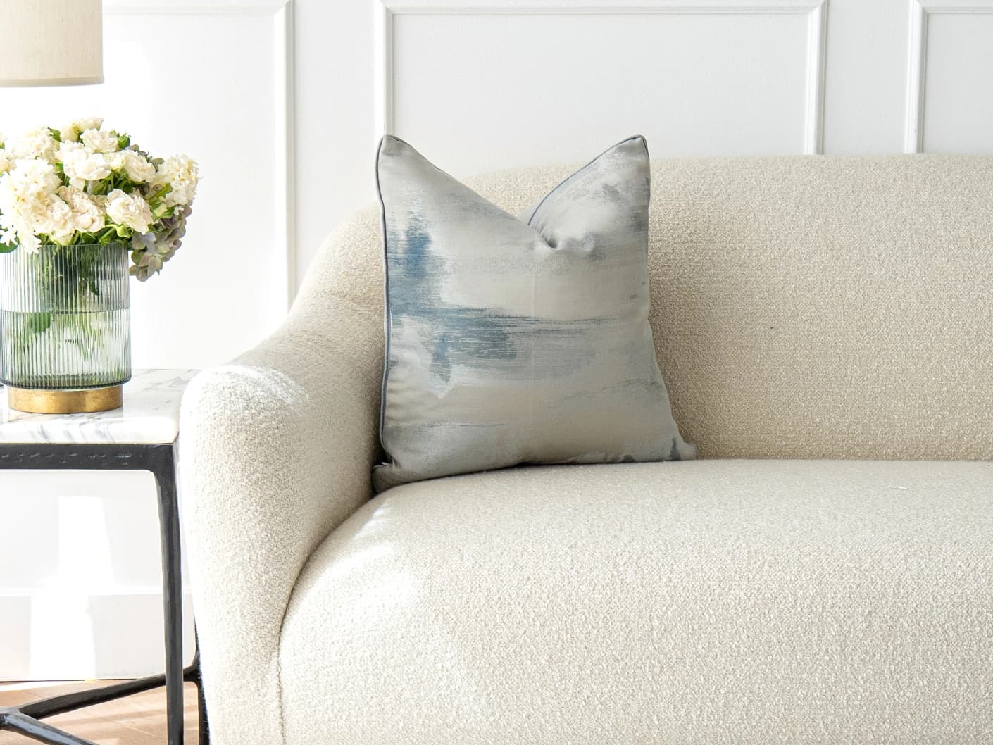 Alma Canova single cushions in blue and silver, shown in a lifestyle front view