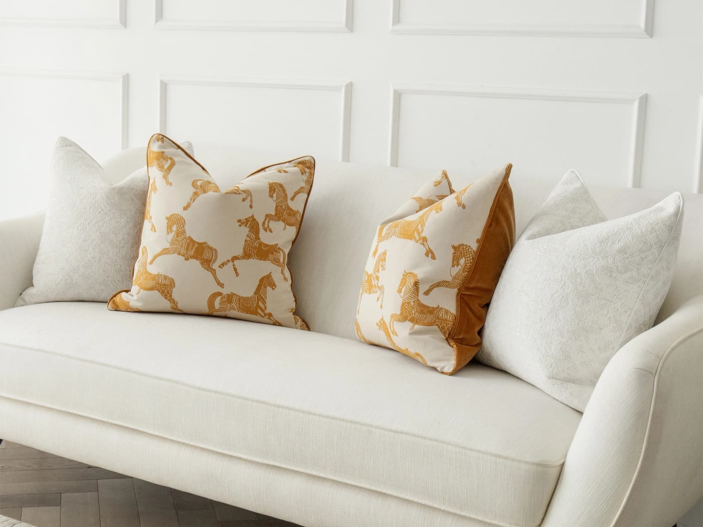 Alona Bundle bundle cushions in white, orange and beige, shown in a lifestyle front view