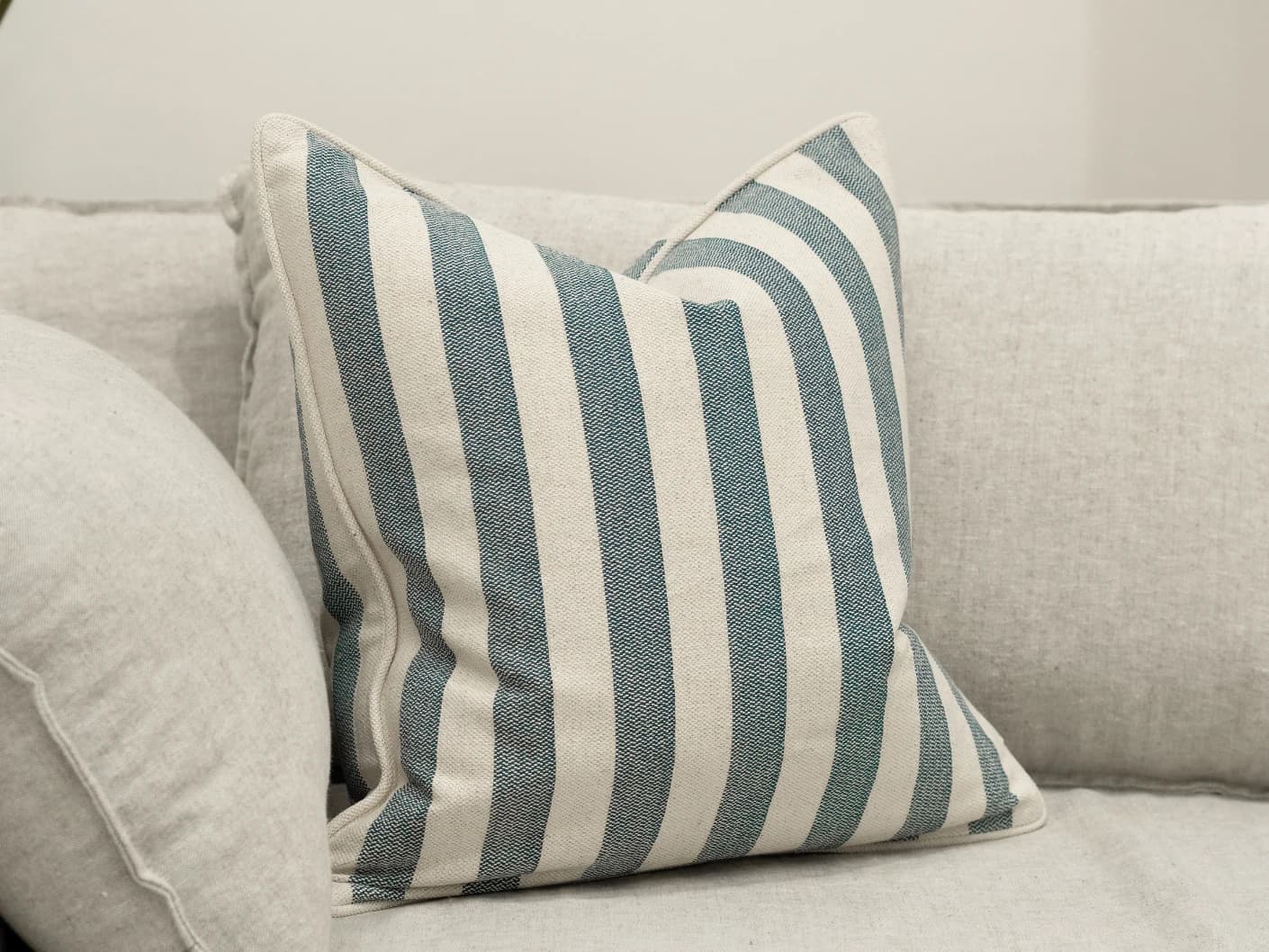 Ameline Canova single cushions in blue, shown in a lifestyle front view