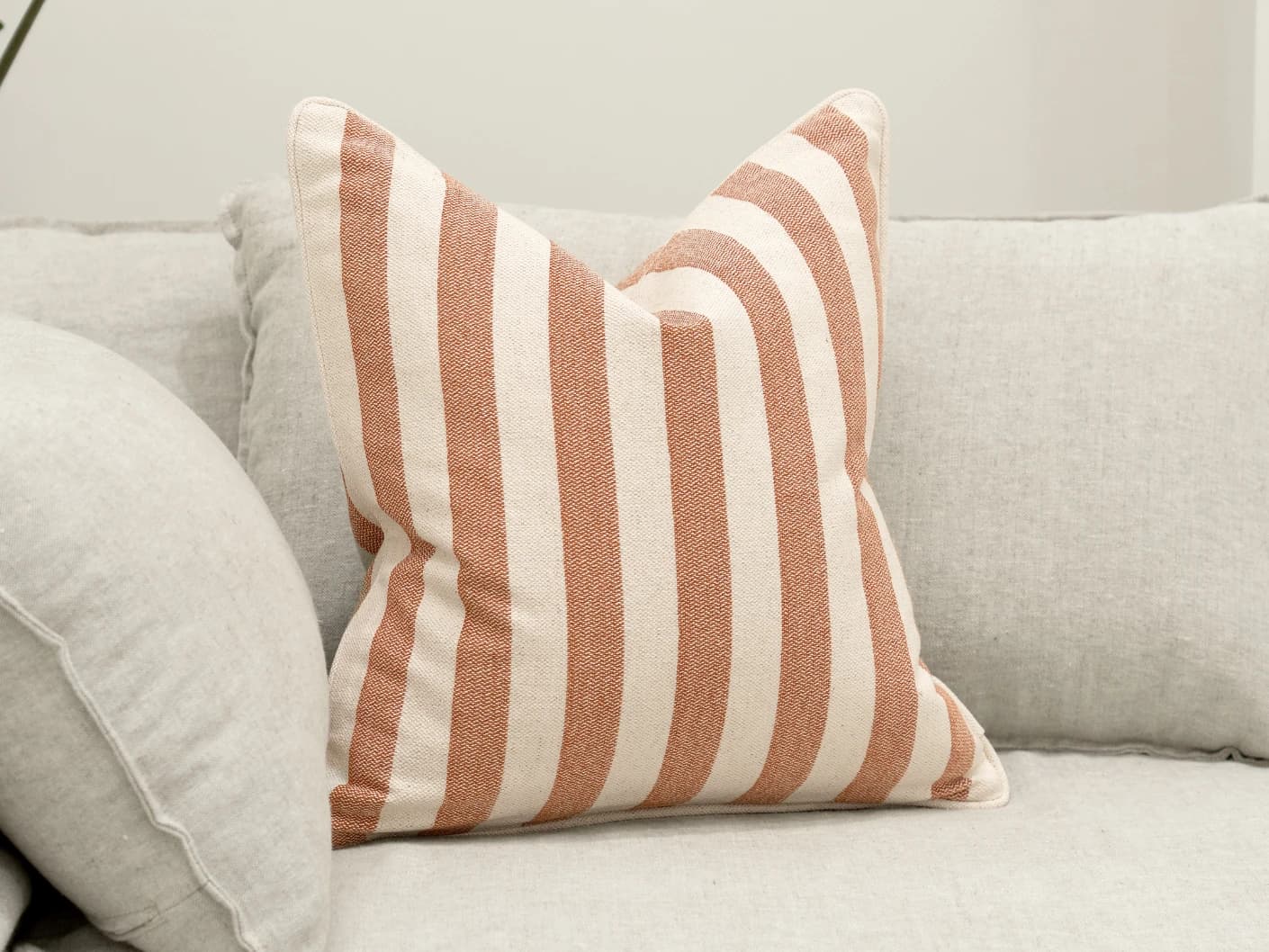 Ameline Rust single cushions in rust, shown in a lifestyle front view