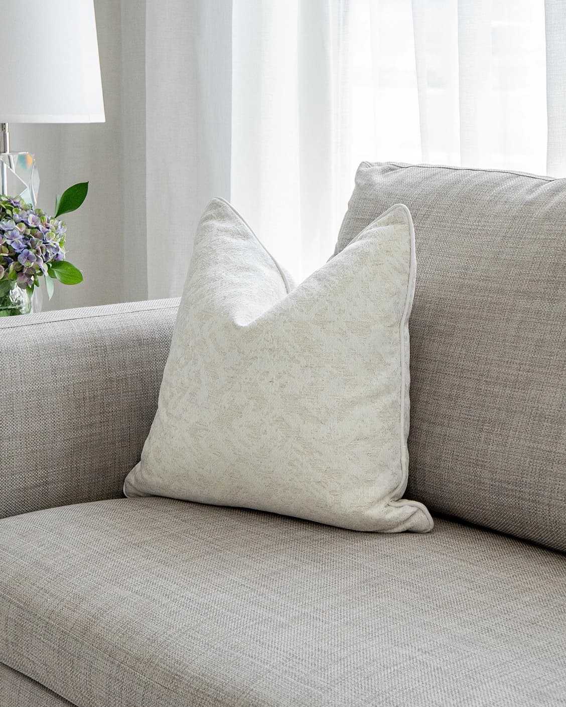 Arcie Bianca cushion in white, shown in a lifestyle front view as image 2