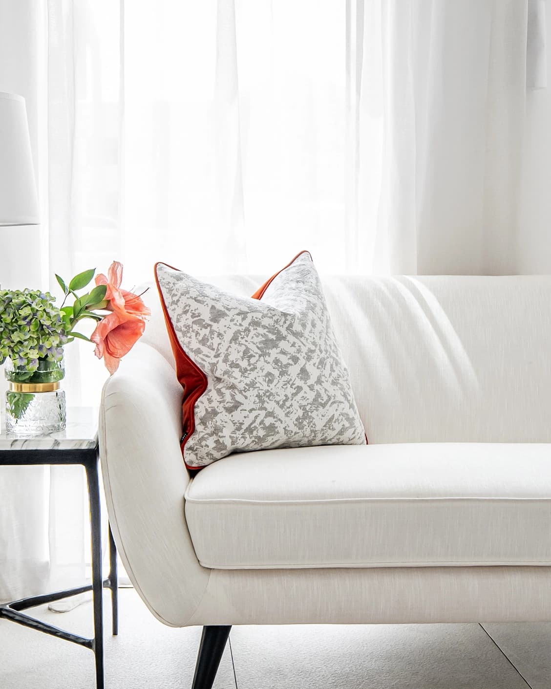 Arcie Tangelo cushion in tangelo, white, grey and orange, shown in a lifestyle front view as image 2