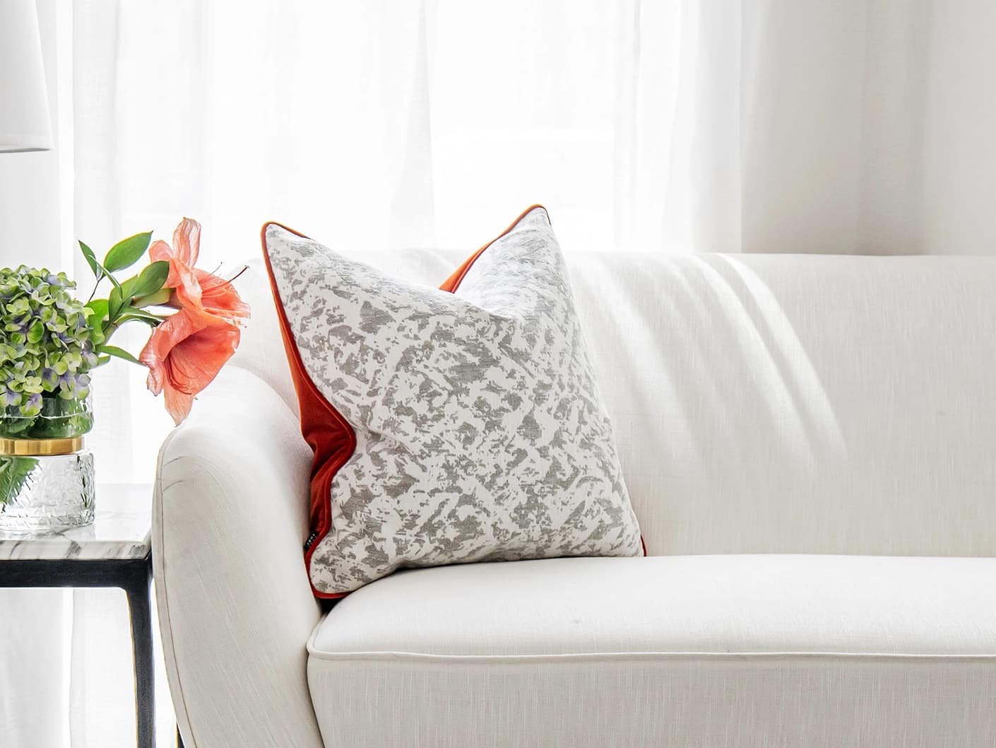 Arcie Tangelo single cushions in tangelo, white, grey and orange, shown in a lifestyle front view