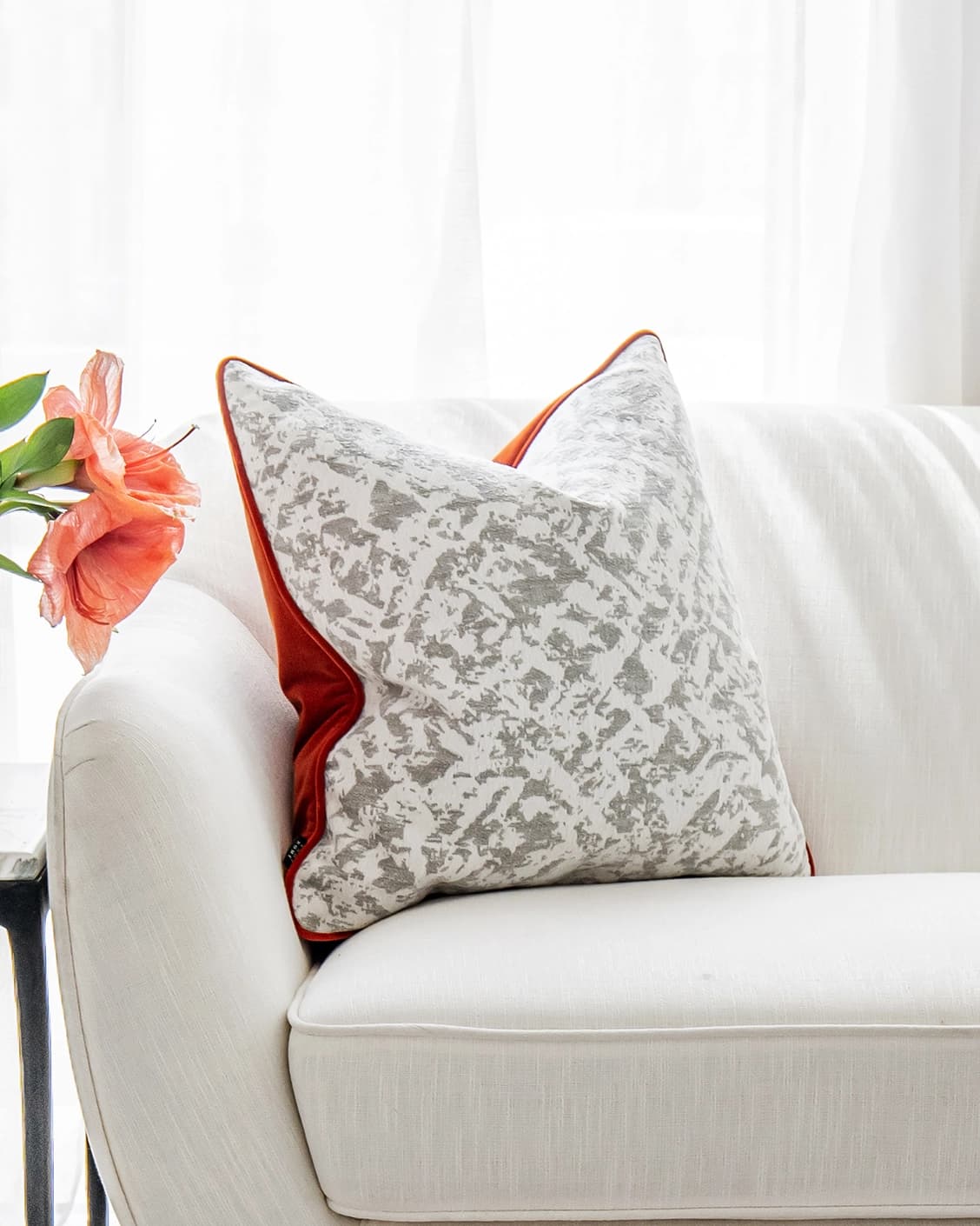Arcie Tangelo cushion in tangelo, white, grey and orange, shown in a lifestyle front view as image 4