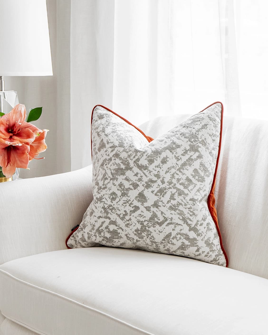 Arcie Tangelo cushion in white, grey and orange, shown in a lifestyle right view as image 1