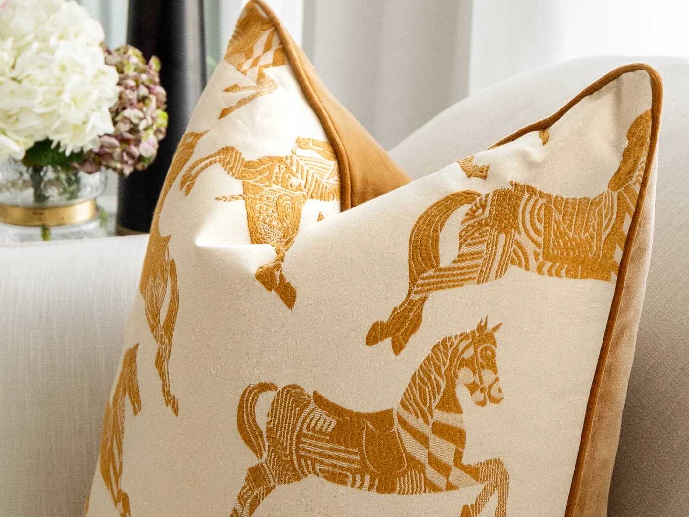 Arie Bundle bundle cushions in orange and beige, shown in a lifestyle close-up front view