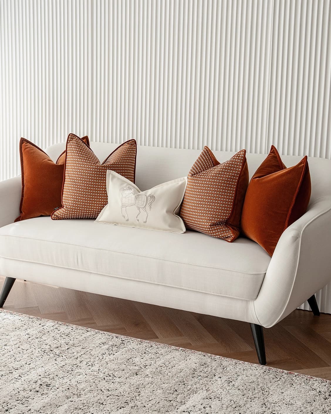 Auburn Bundle cushion in rust, white and orange, shown in a lifestyle front view as image 2