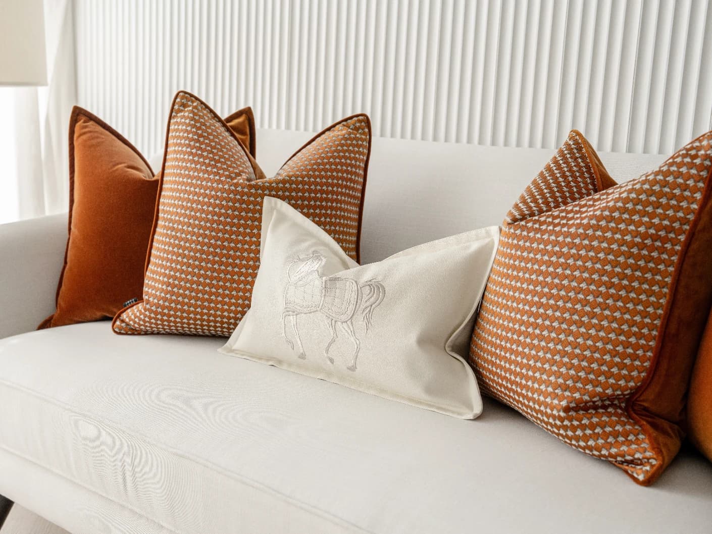 Auburn Bundle bundle cushions in rust, white and orange, shown in a lifestyle front view