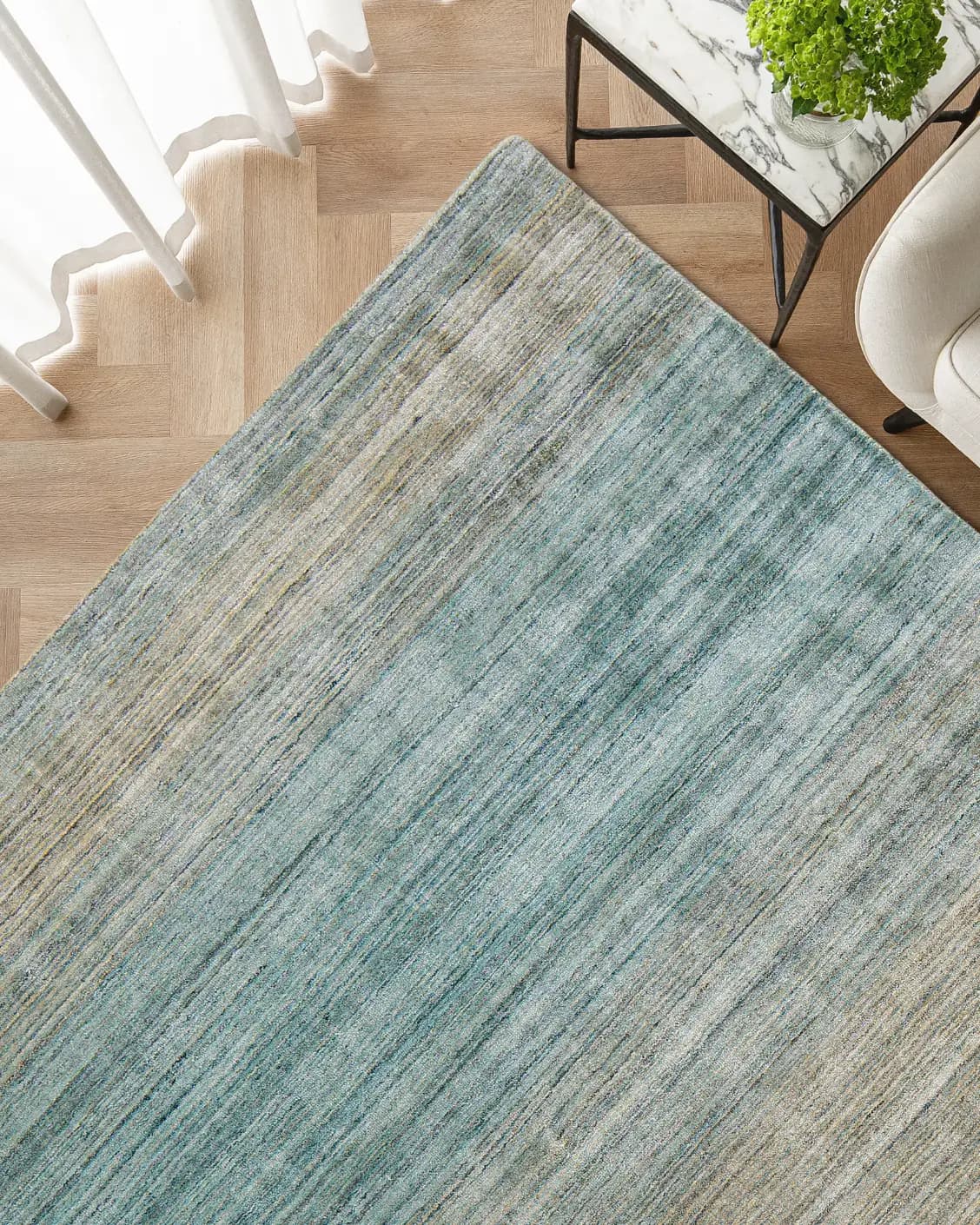 Ava Sandy carpet in sandy, turquoise and beige, shown in a lifestyle top view as image 2
