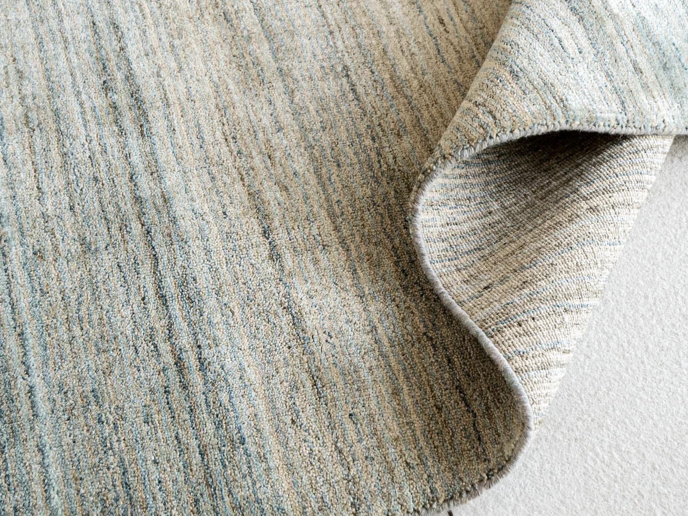 Ava Sandy carpets in sandy, turquoise and beige, shown in a product close-up top view