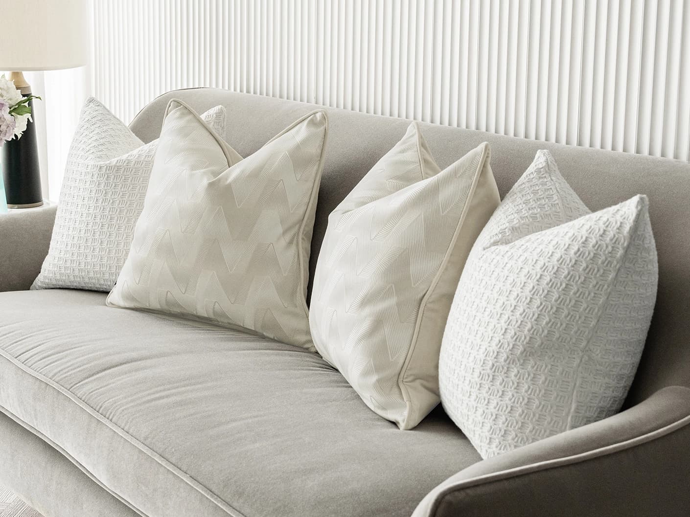 Aynura Bundle bundle cushions in white, beige and silver, shown in a lifestyle front view