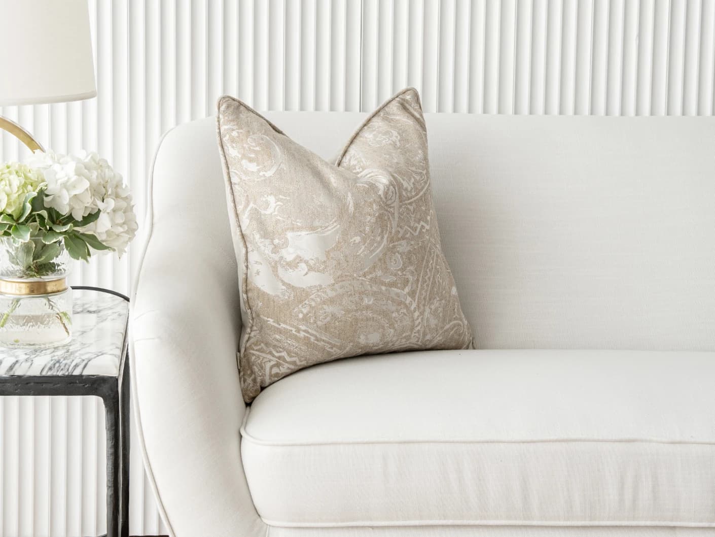 Berti Hodler single cushions in beige and silver, shown in a lifestyle front view