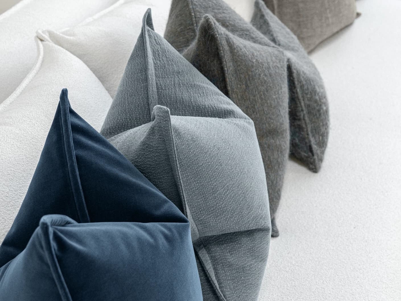 Bracia Bundle bundle cushions in brown, grey and blue, shown in a product front view