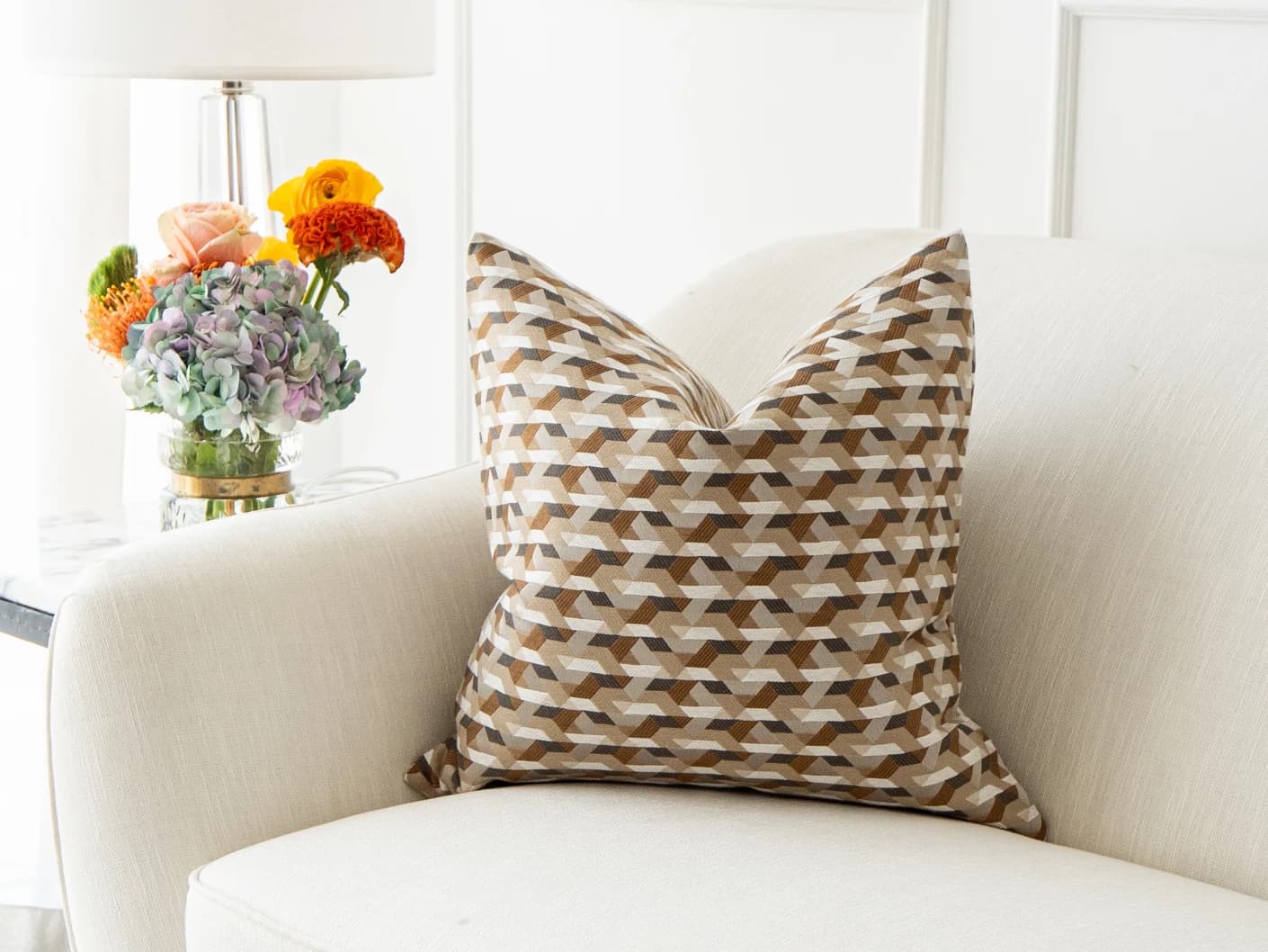 Brianna Laurent single cushions in orange and beige, shown in a lifestyle front view