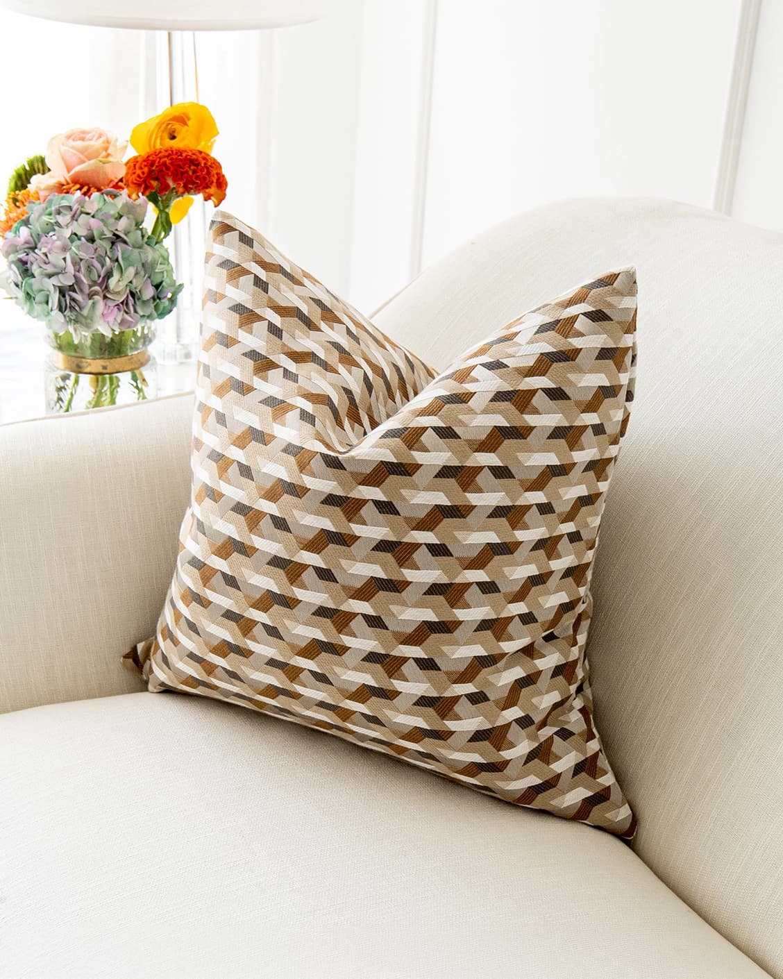 Brianna Laurent cushion in orange and beige, shown in a lifestyle top view as image 2