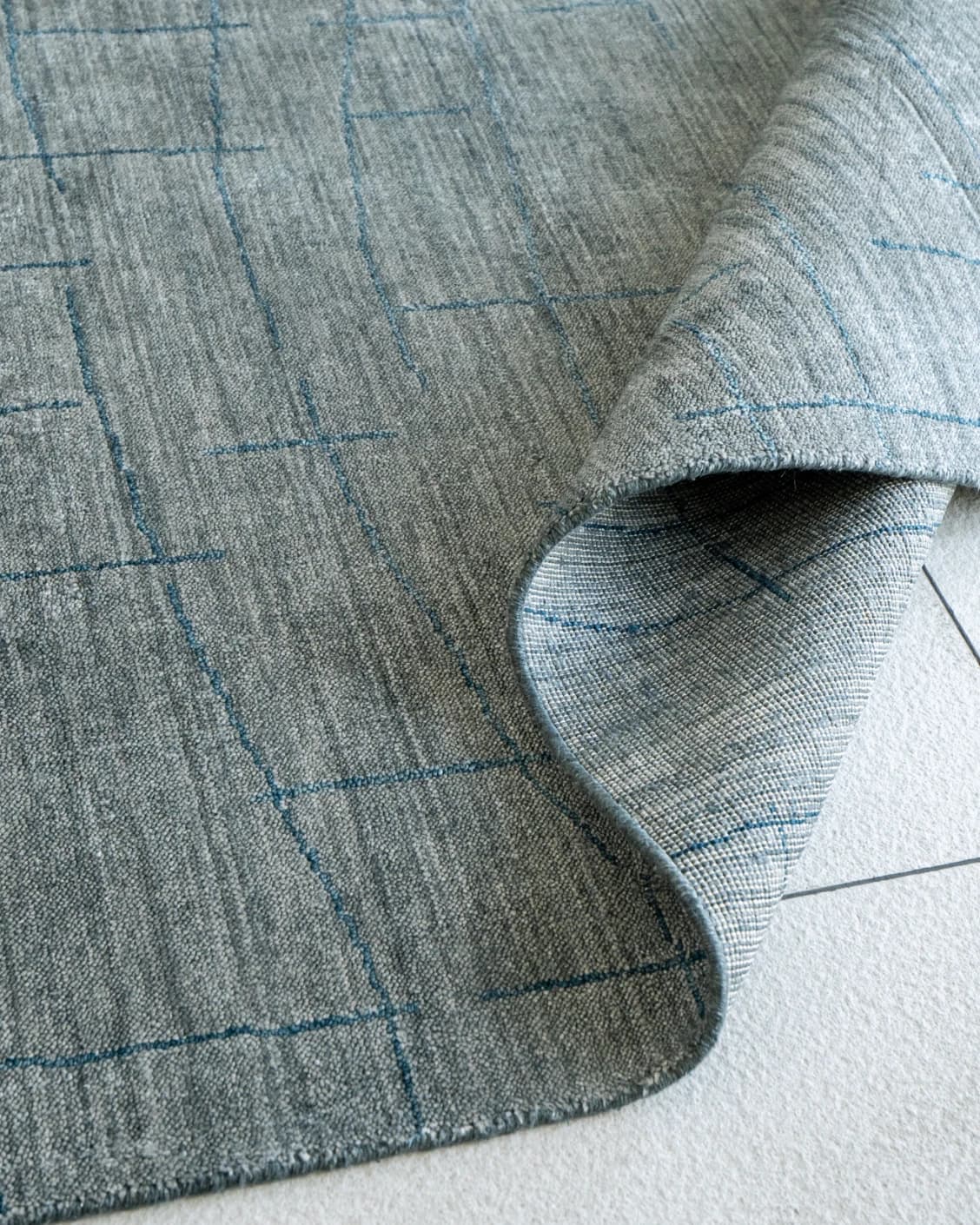 Caleb Ashton carpet in grey, teal and blue, shown in a product close-up as image 4