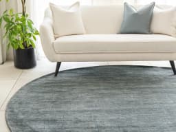 Caleb Ashton Round carpet in grey, teal and blue, shown in a lifestyle front view