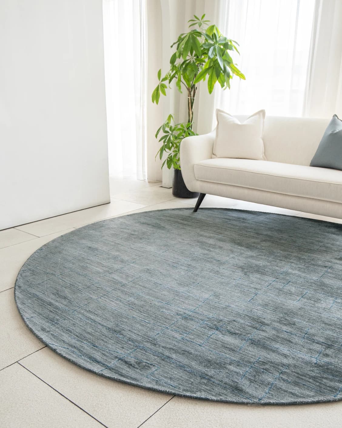 Caleb Ashton Round carpet in grey, teal and blue, shown in a lifestyle right view as image 10