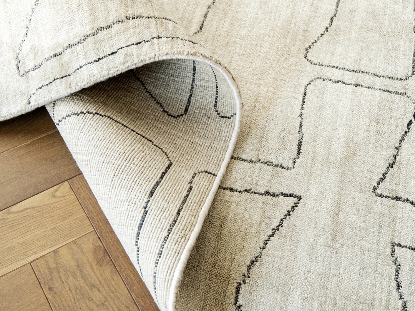 Caleb Ebony Round carpets in ebony, pearl and grey, shown in a product close-up view