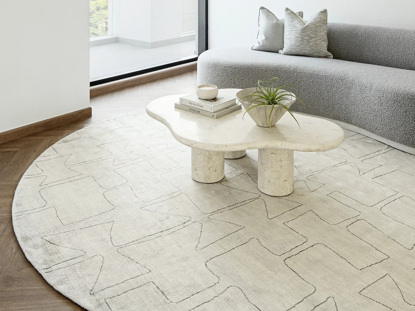 Caleb Ebony Round carpet in pearl and grey, shown in a lifestyle right view