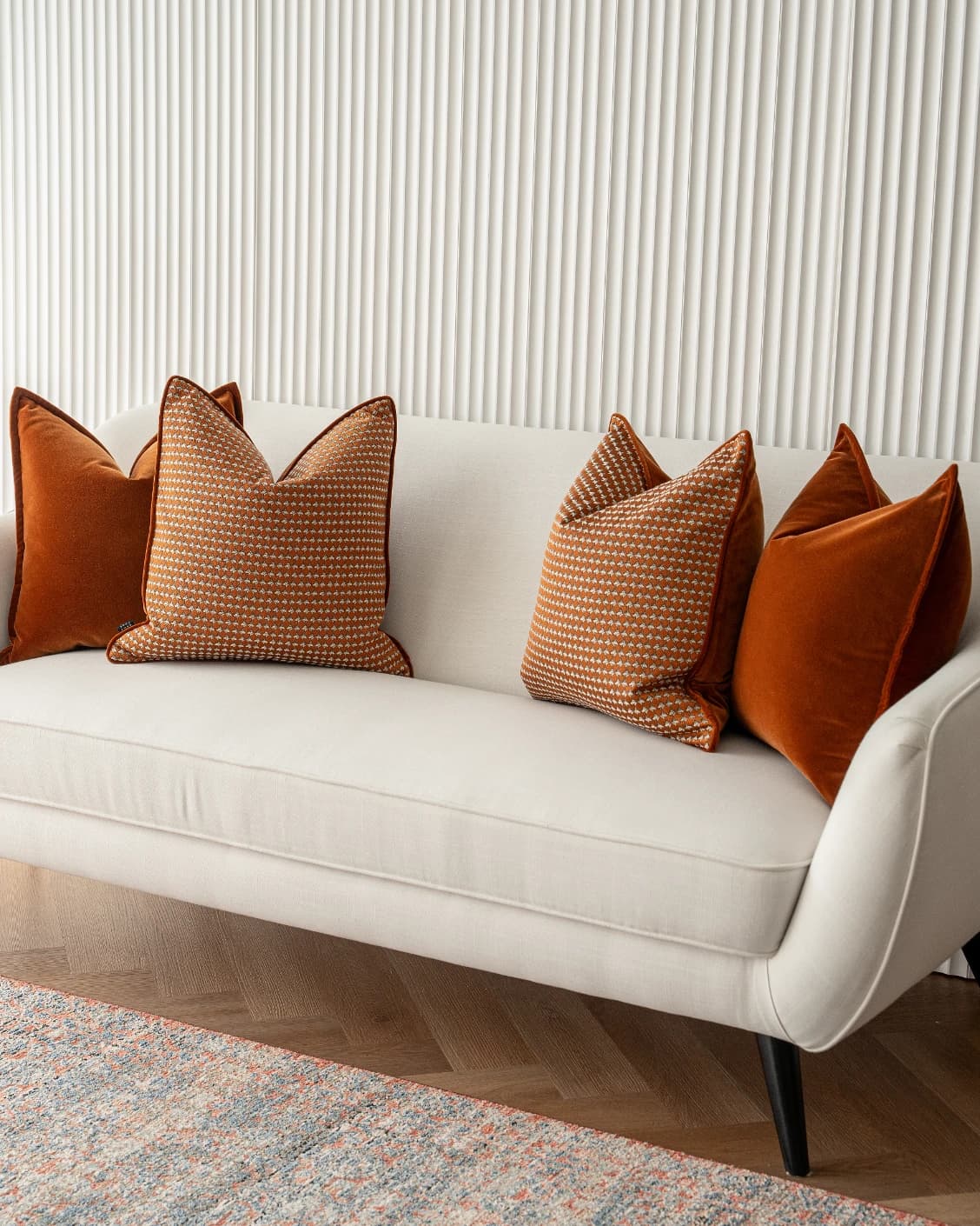 Callan Bundle cushion in rust and orange, shown in a lifestyle front view as image 2