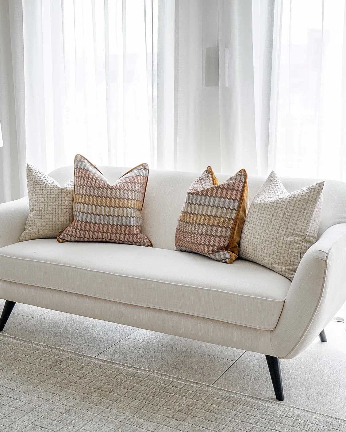 Camella Bundle cushion in orange, yellow, silver and white, shown in a lifestyle front view as image 2