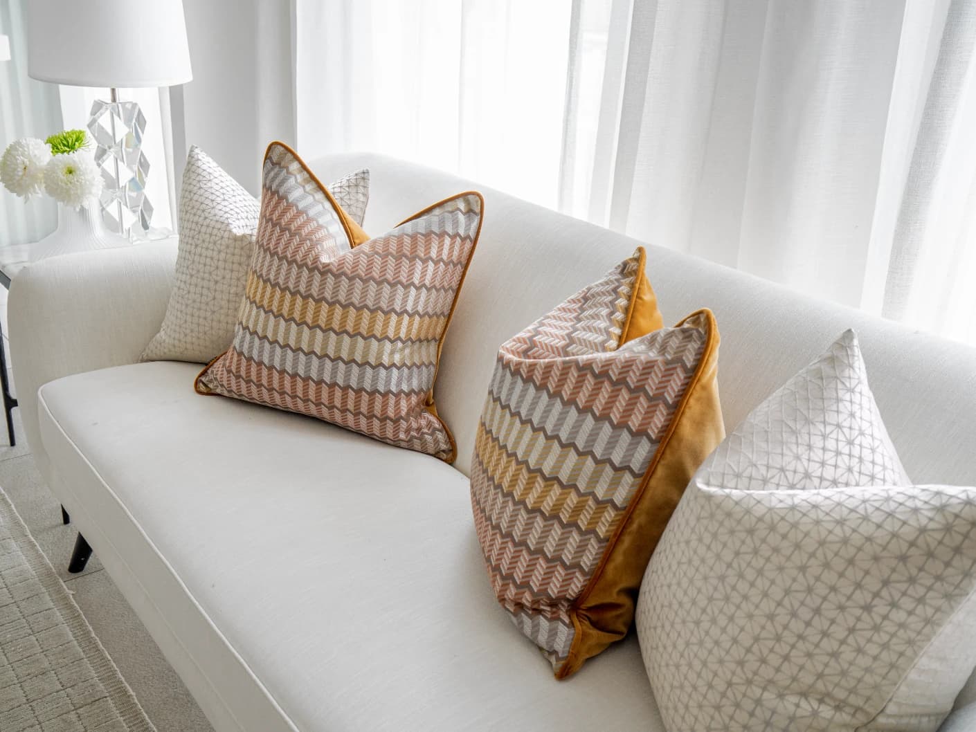 Camella Bundle bundle cushions in orange, yellow, silver and white, shown in a lifestyle front view