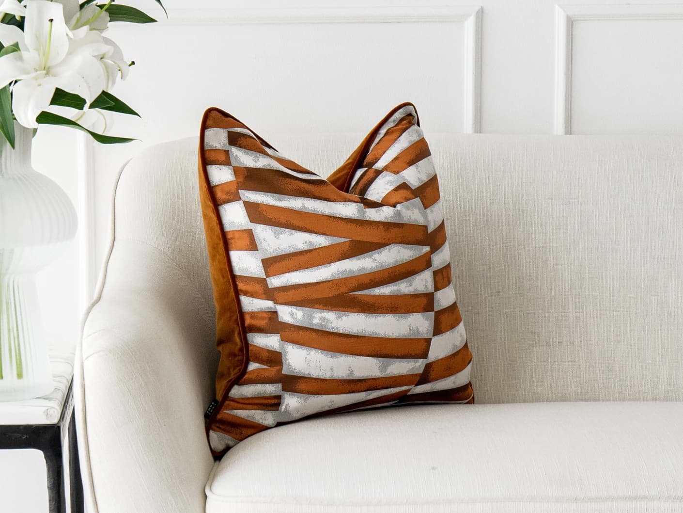 Carlie Hodler single cushions in orange and white, shown in a lifestyle left view