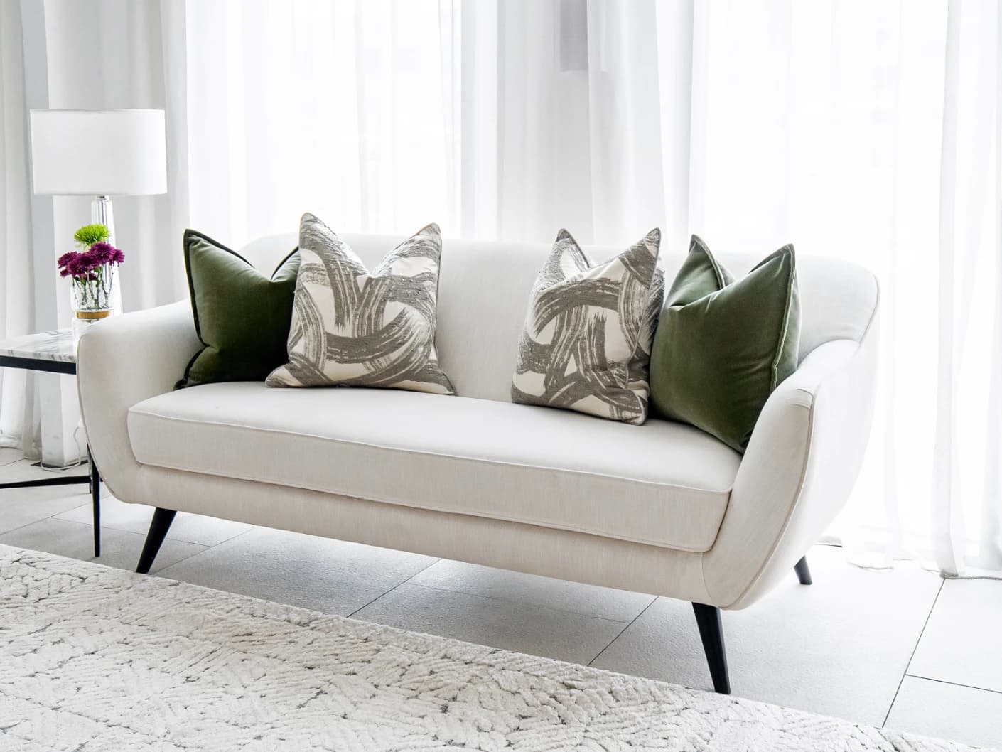 Cattleya Bundle bundle cushions in green, white and grey, shown in a lifestyle front view