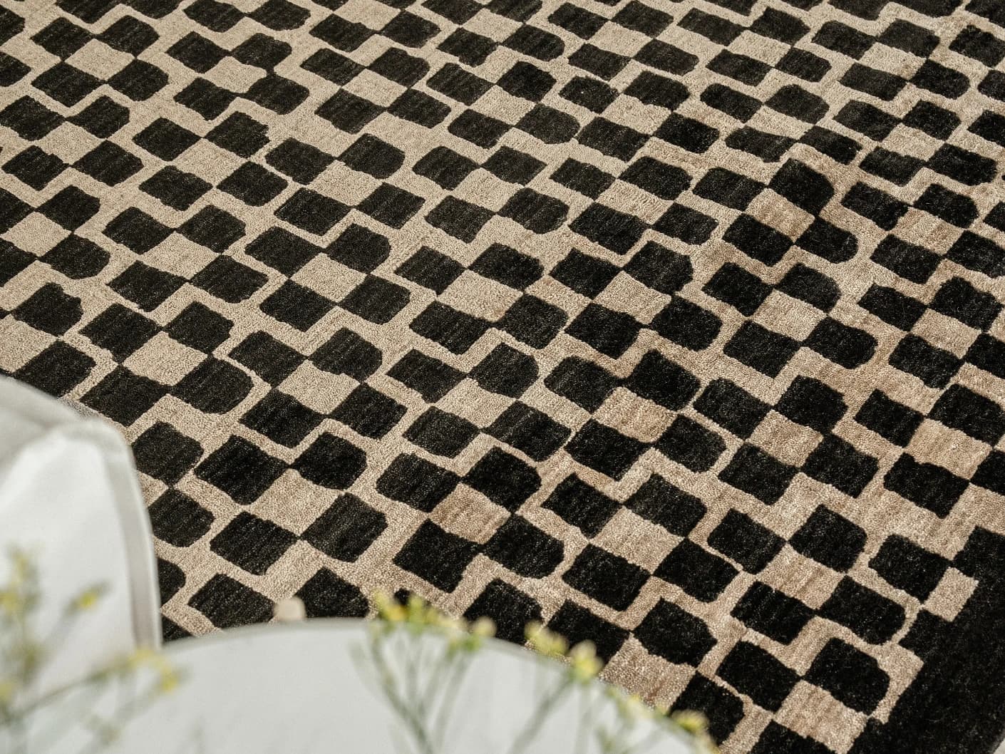 Chess Ebony carpets in beige and black, shown in a lifestyle close-up top view as image 2