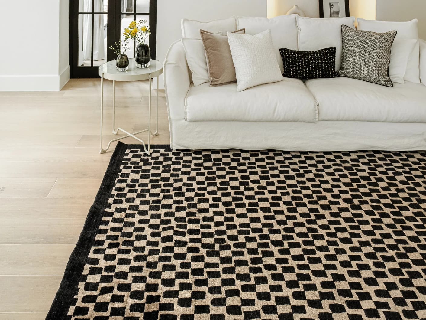 Chess Ebony carpets in beige and black, shown in a lifestyle close-up top view as image 1