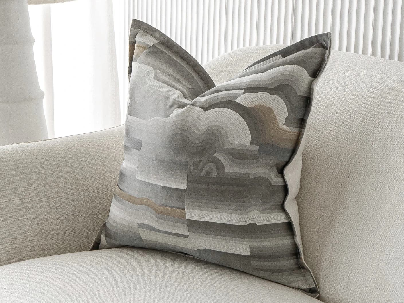 Claudine Laurent single cushions in grey, shown in a lifestyle front view