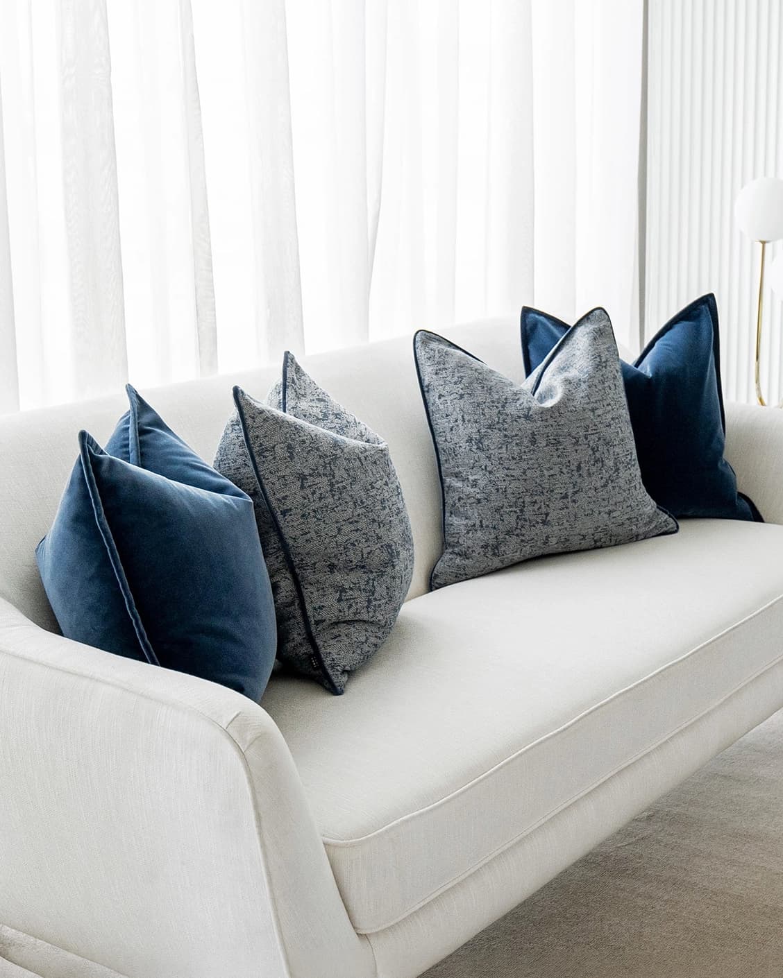 Clea Bundle cushion in navy, grey and royal blue, shown in a lifestyle left view as image 2