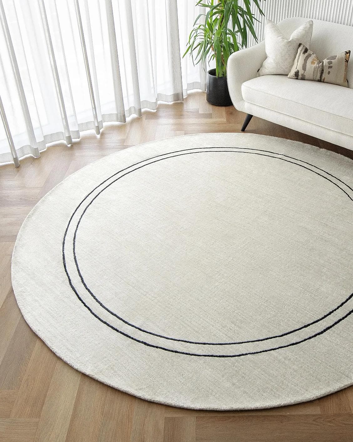 Colin Bianca Round carpet in white, black and pearl, shown in a lifestyle top view as image 5