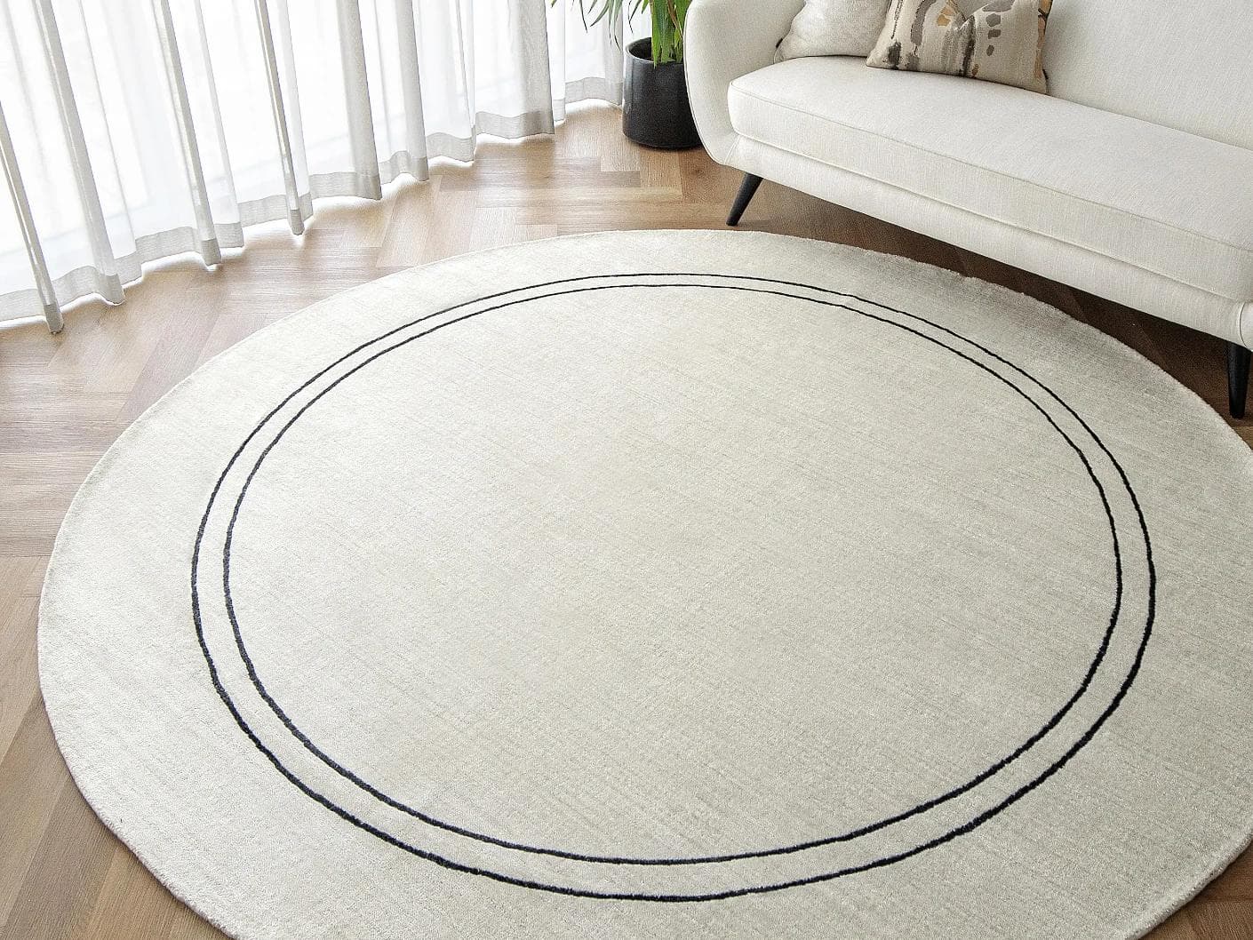Colin Bianca Round carpet in white, black and pearl, shown in a lifestyle top view as image 5