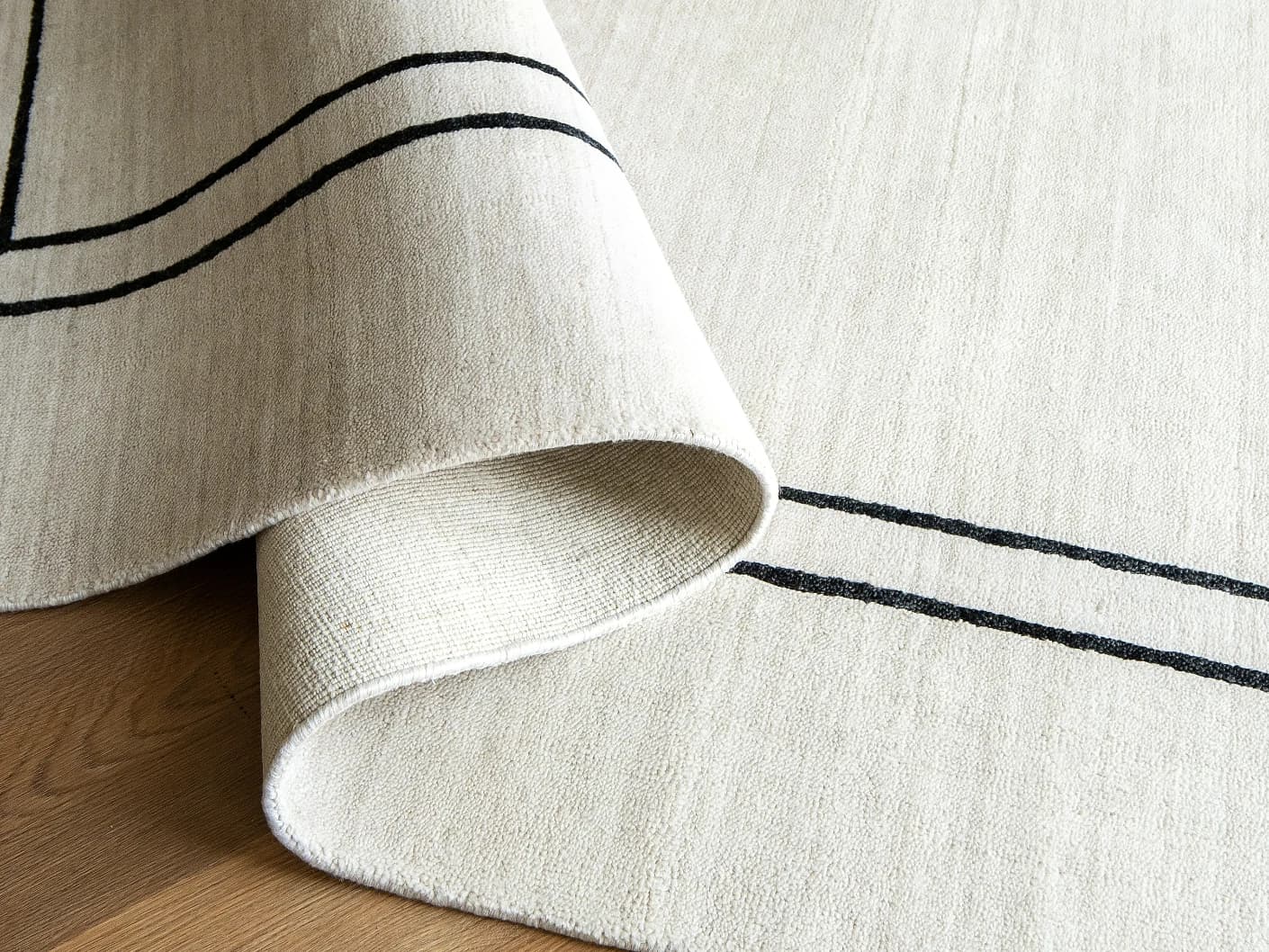 Colin Bianca carpets in white, black and pearl, shown in a product close-up front view