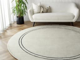 Colin Bianca Round carpet in white, black and pearl, shown in a lifestyle front view