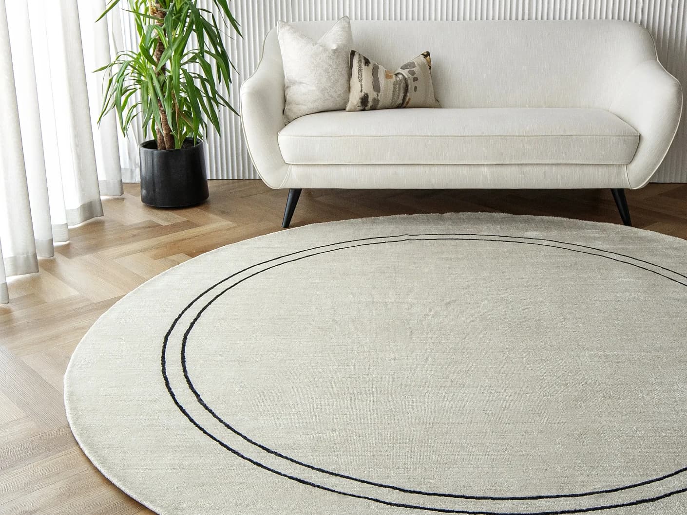 Colin Bianca Round carpet in white, black and pearl, shown in a lifestyle front view