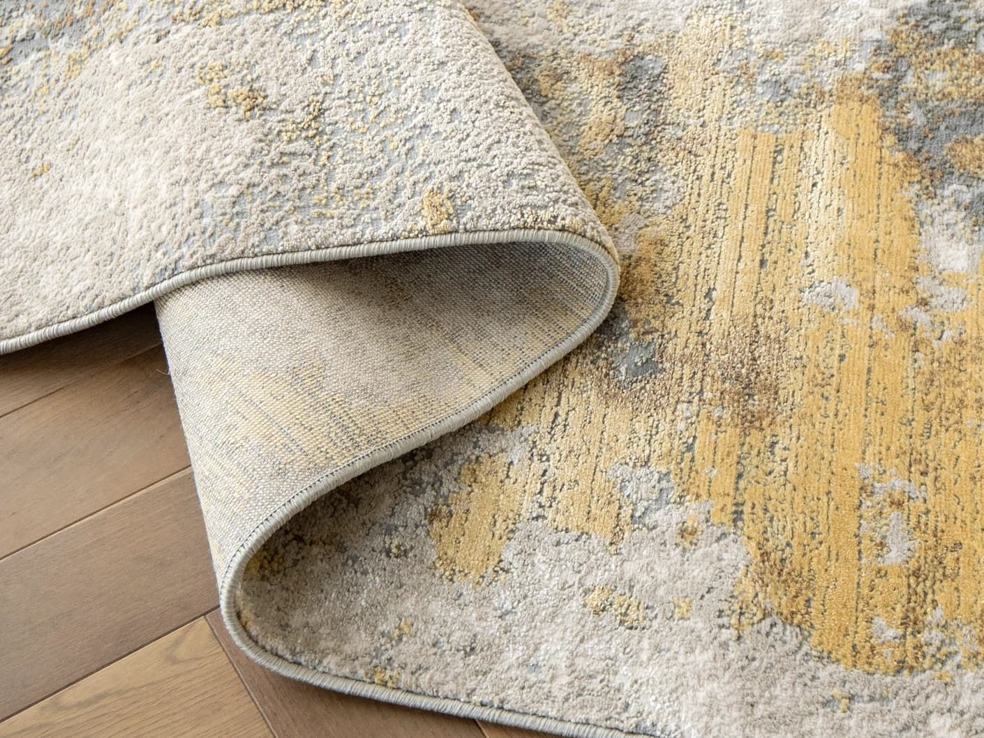 Cooper Goldberg carpets in grey and gold, shown in a product close-up left view